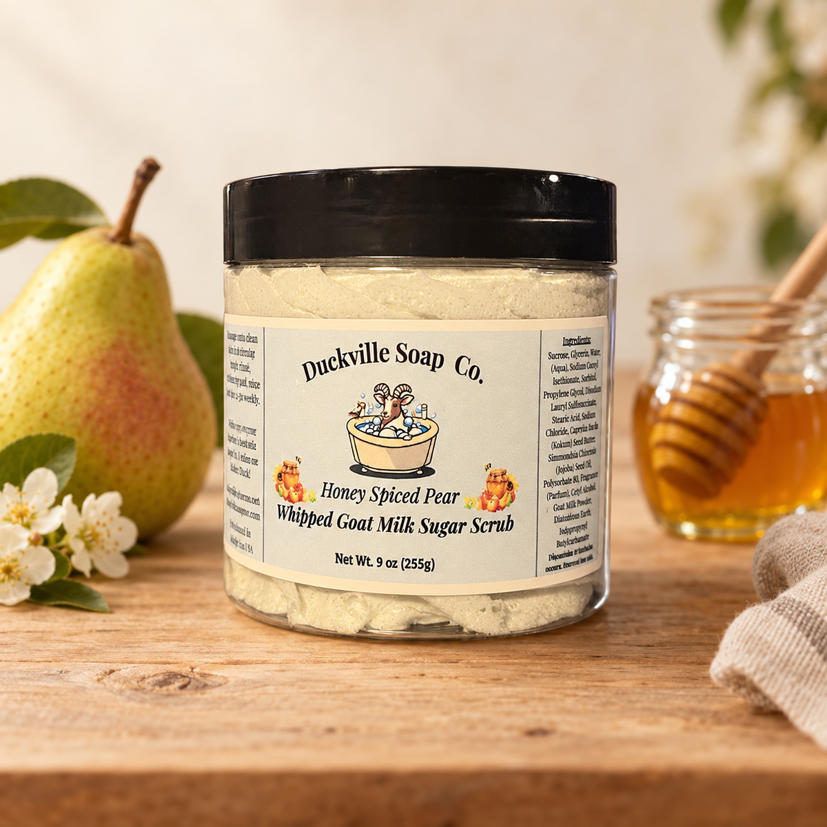 Honey Spiced Pear Duckville whipped goat milk sugar scrub in a labeled 9 oz jar beside a pear