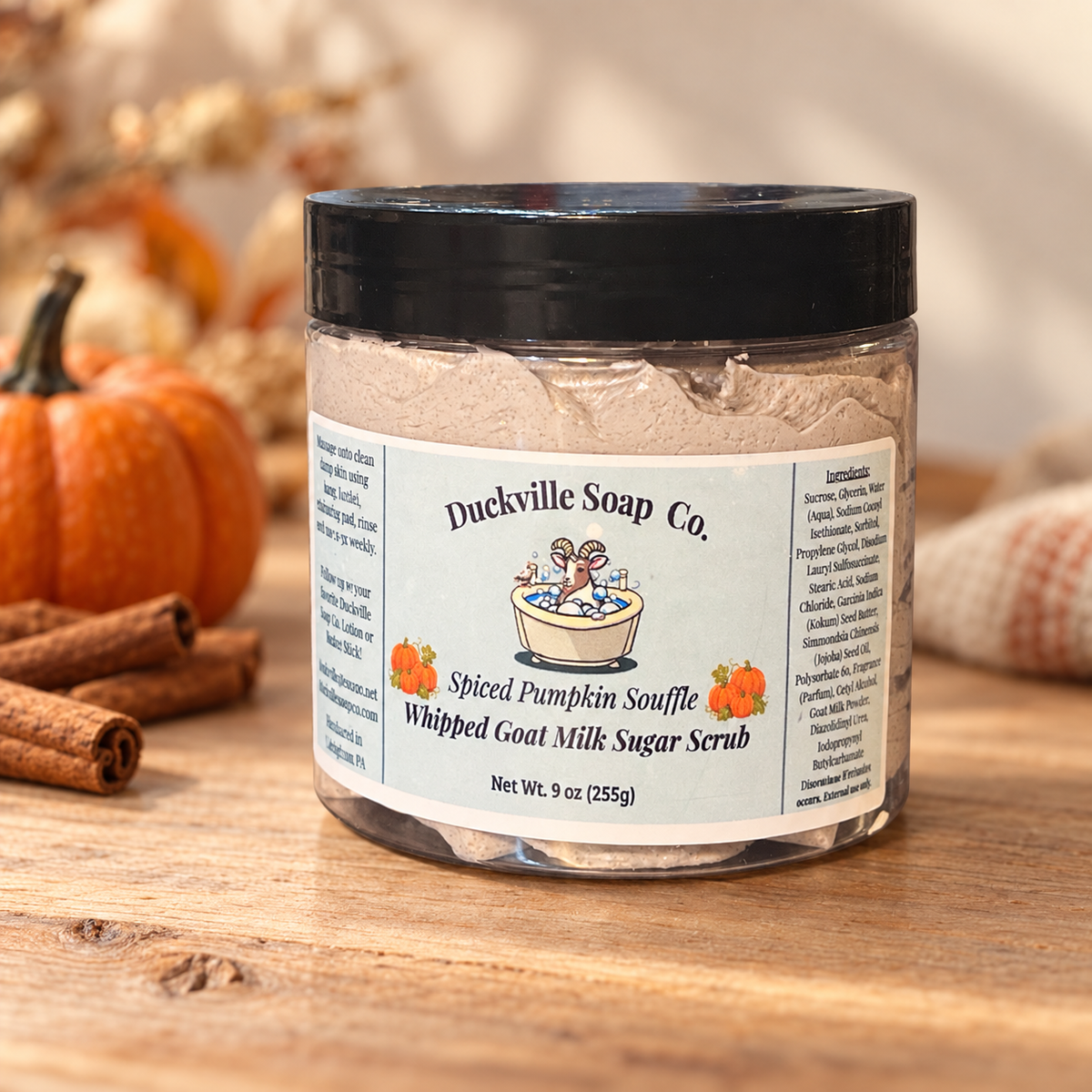 Spiced Pumpkin Souffle Duckville whipped goat milk sugar scrub in a labeled 9 oz jar beside pumpkins