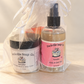 Paradise hand and body cream and body and hair mist, with soap behind them, in a sheer white gift bag.